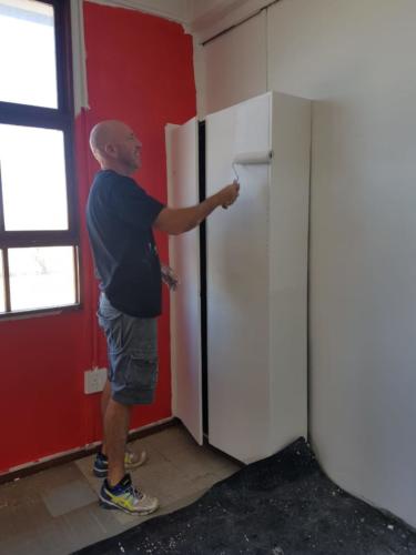 Jacques painting cupboards in library